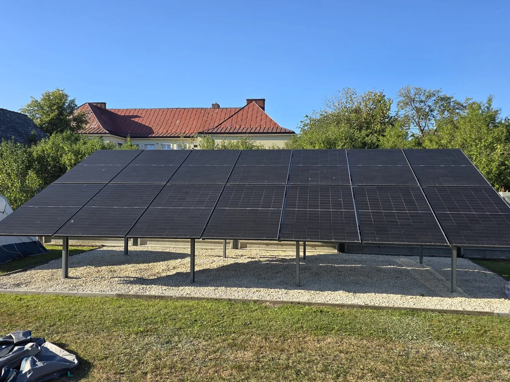 Instalacja fotowoltaiczna na konstrukcji gruntowej, na żwirowym podłożu przy domu